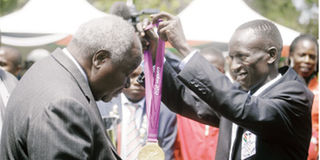 Ezekiel Kemboi decorates President Mwai Kibaki with his Olympic gold medal 