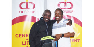 CIC Insurance Group tournament overall winner Simon Karemu (left) receives the prize from CIC Group acting CEO Elijah Wachira